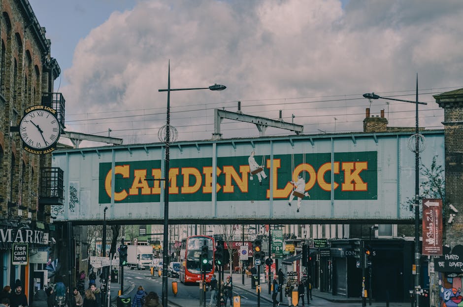 A small, two-story brick building with a blue sign reading 'Camden Quality Fish' and mentioning fresh fish and seafood, positioned on a street corner in North West London. The storefront features a la